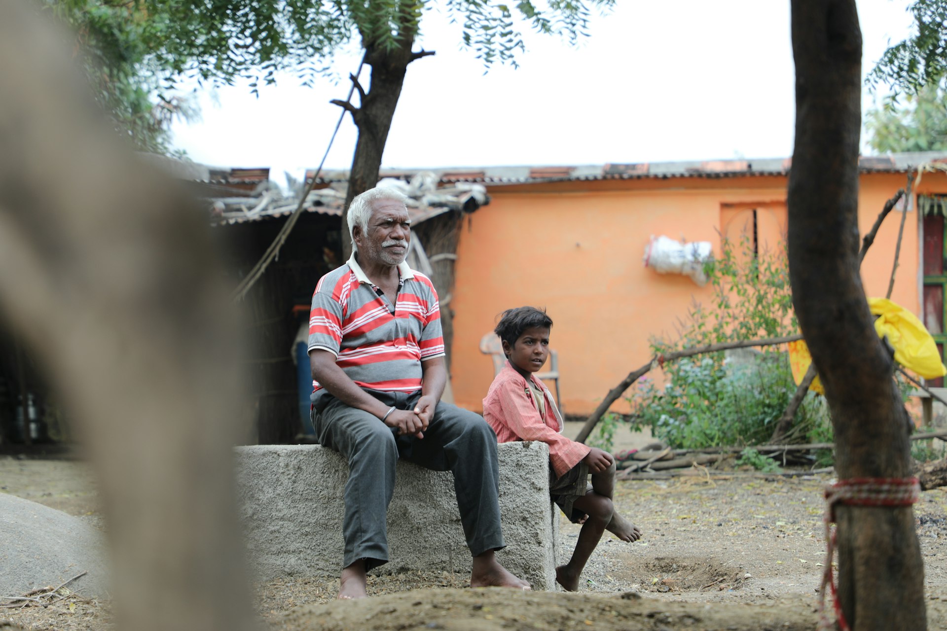man and woman sitting on concrete bench during daytime